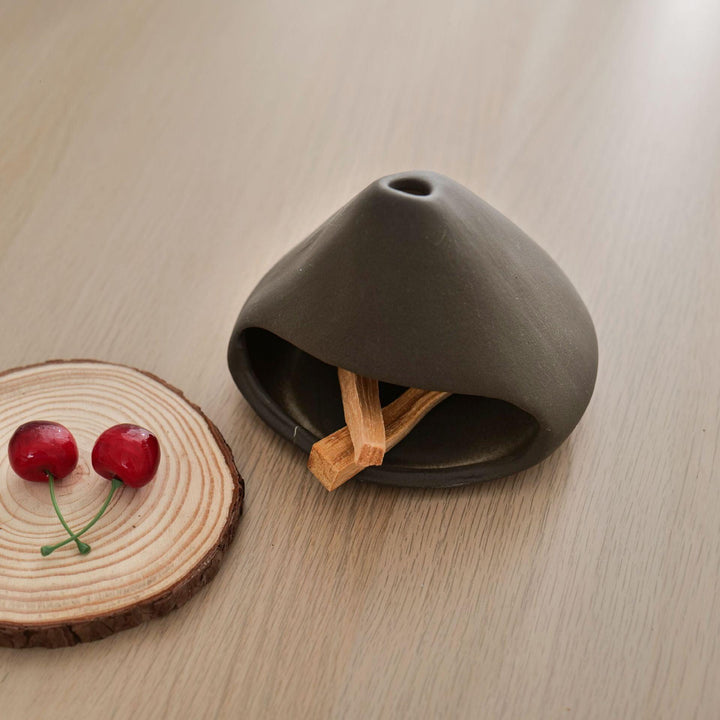 grey ceramic incense cone shape burner holder on the table