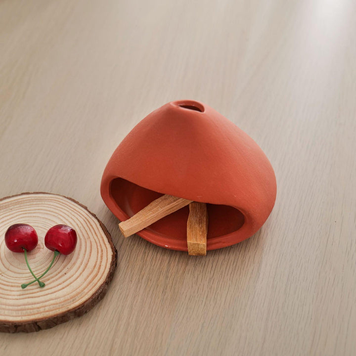 red ceramic incense cone shape burner holder on the table