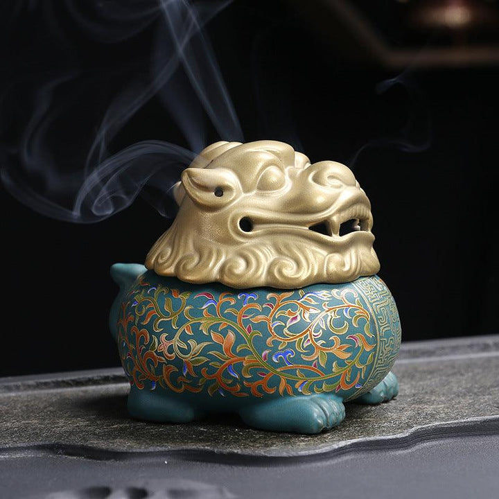 colorful mythical animal in enamel incense burner holder on the table