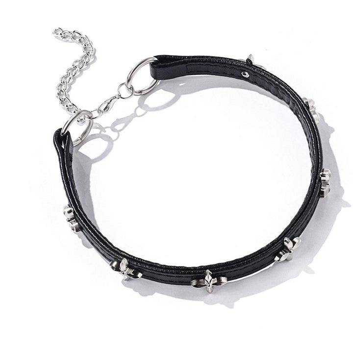 a black gothic cross leather choker on the table