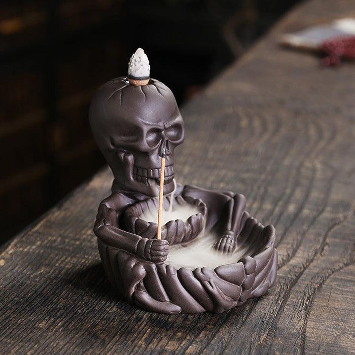 a gothic dark skeletal backflow incense burner holder on the table